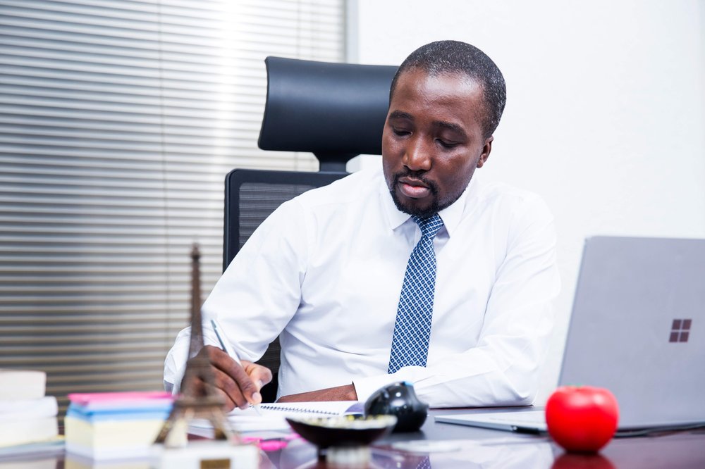 Derrydean Dadzie writing at his desk